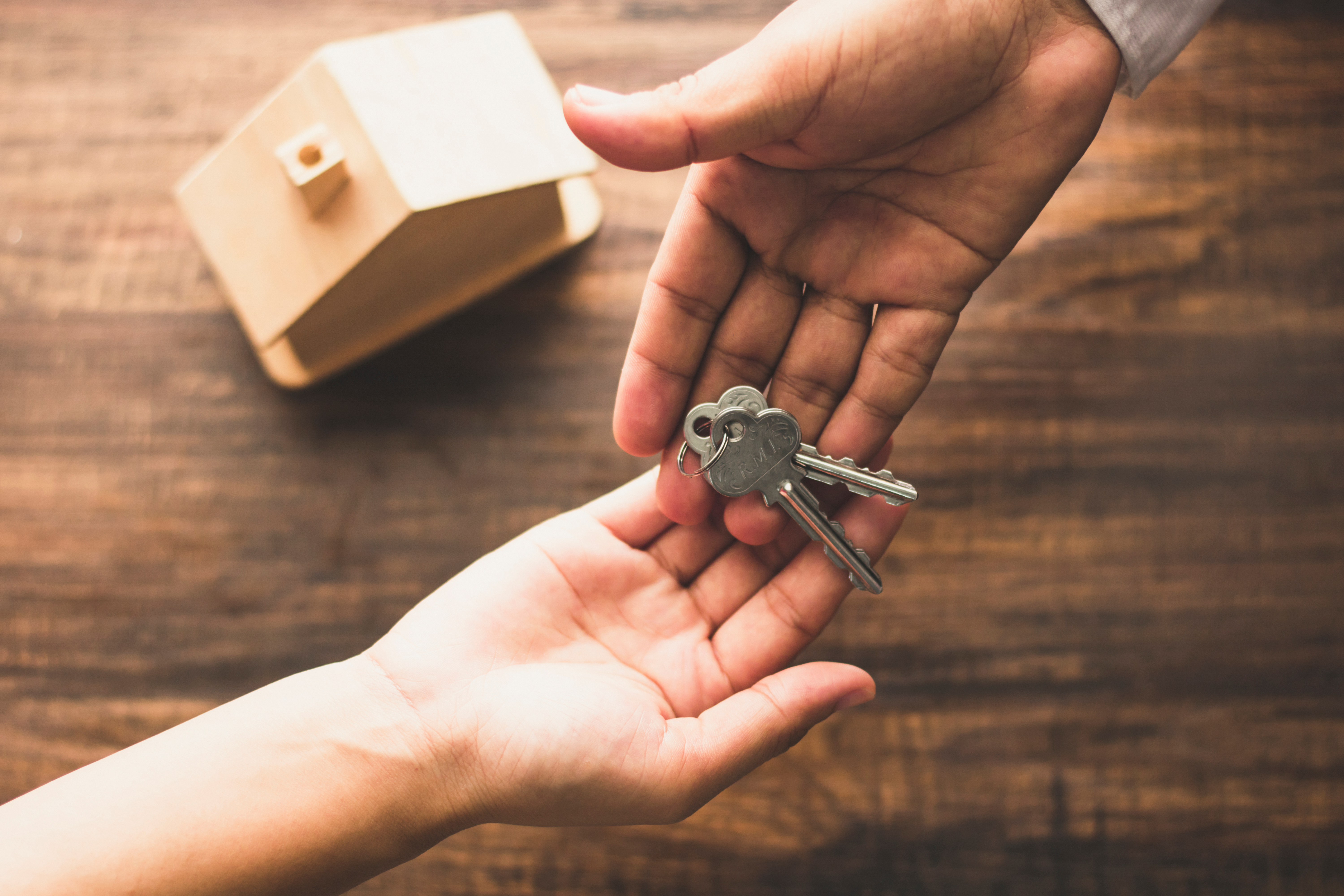 A broker handing off house keys to their client